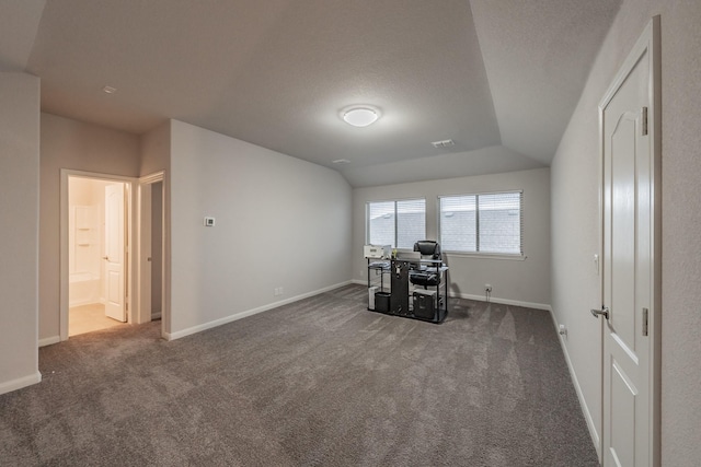 unfurnished office featuring lofted ceiling, carpet, baseboards, and a textured ceiling