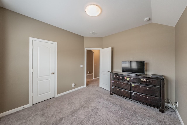 carpeted bedroom with vaulted ceiling and baseboards