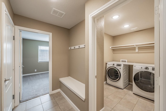 laundry room with light tile patterned floors, visible vents, laundry area, independent washer and dryer, and baseboards