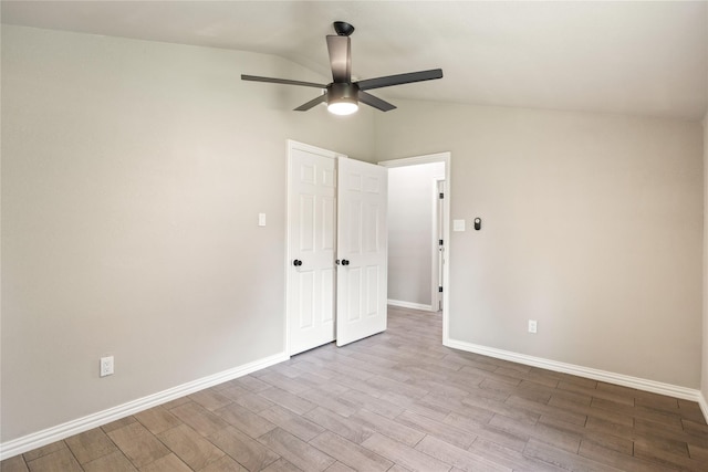 unfurnished bedroom with vaulted ceiling, ceiling fan, wood finished floors, and baseboards