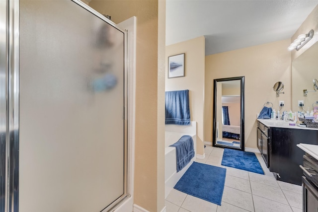 bathroom featuring a bath, a stall shower, tile patterned flooring, and vanity