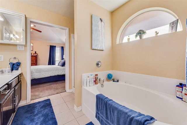 ensuite bathroom with connected bathroom, vanity, tile patterned flooring, plenty of natural light, and a bath