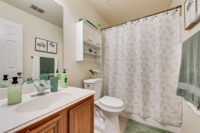 bathroom featuring toilet, vanity, visible vents, and tile patterned floors