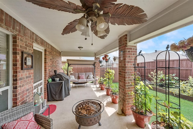 view of patio / terrace with ceiling fan, a fenced backyard, and an outdoor living space with a fire pit