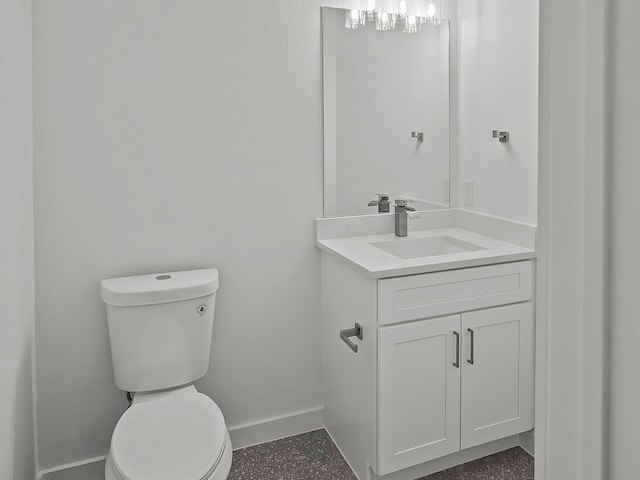 bathroom with baseboards, vanity, and toilet