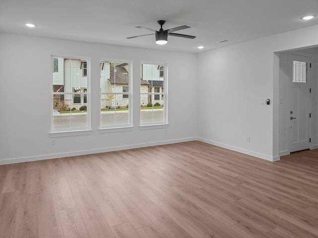 spare room with a ceiling fan, recessed lighting, light wood-style flooring, and baseboards