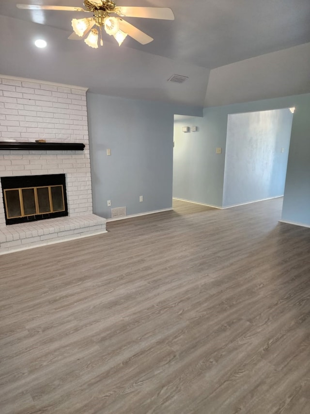 unfurnished living room featuring a ceiling fan, wood finished floors, lofted ceiling, and visible vents