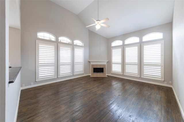 unfurnished living room with baseboards, a fireplace, a ceiling fan, and dark wood-style flooring