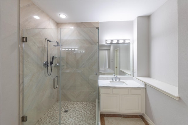 bathroom featuring a marble finish shower, vanity, and tile patterned floors