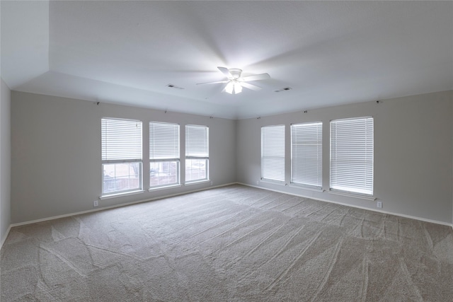 carpeted empty room with visible vents, ceiling fan, and baseboards