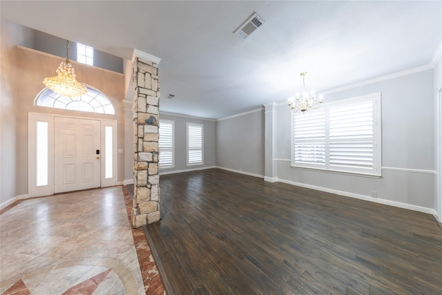 entryway featuring dark wood finished floors, visible vents, ornamental molding, a chandelier, and ornate columns