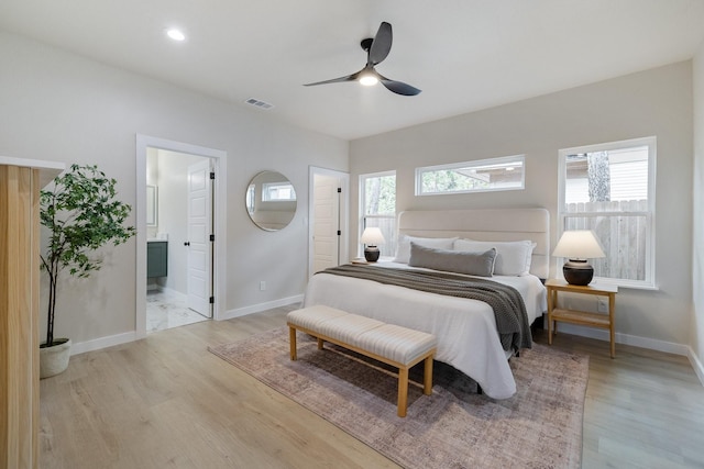 bedroom with light wood-style flooring, visible vents, baseboards, and ceiling fan