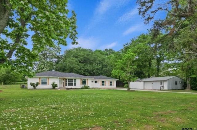 view of front of property featuring a front lawn and an outdoor structure