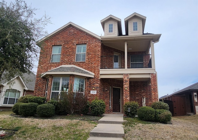 traditional-style house with a balcony and brick siding