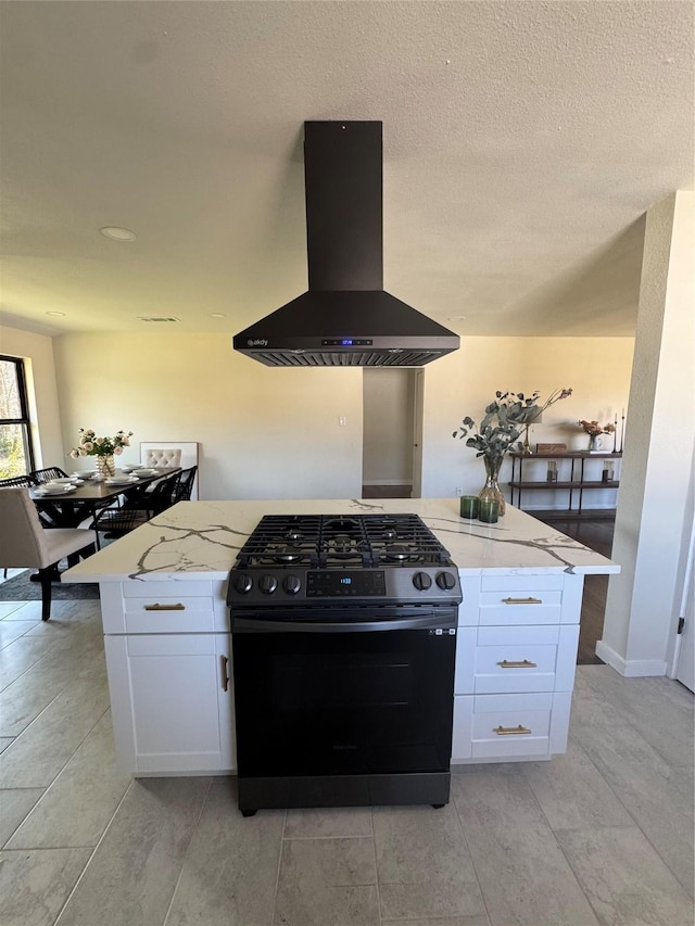 kitchen featuring a center island, white cabinets, black gas stove, ventilation hood, and light stone countertops