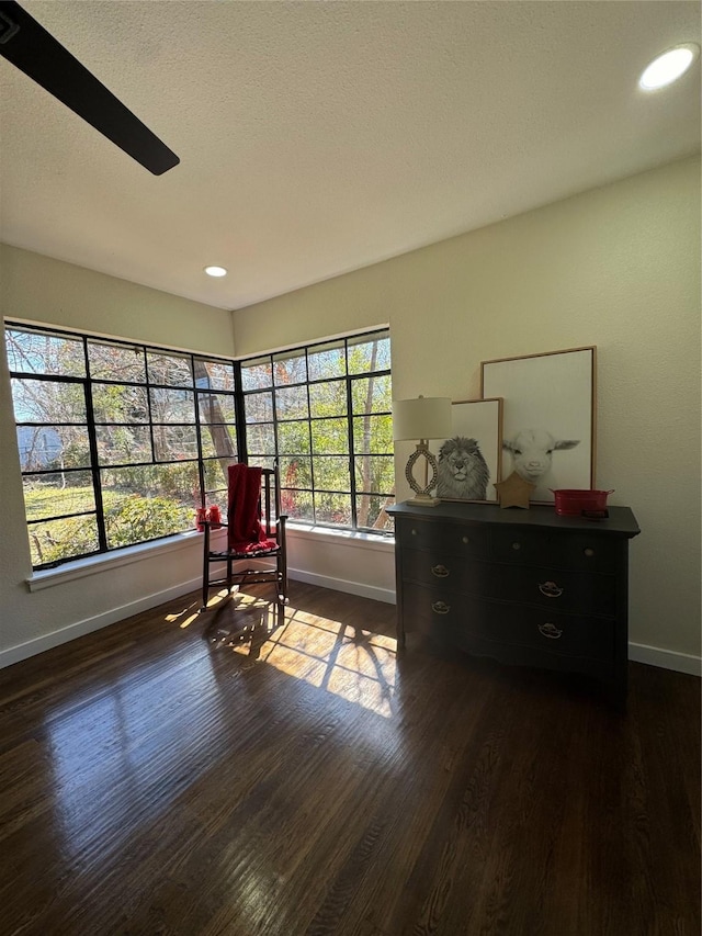 sitting room with a textured ceiling, baseboards, dark wood-type flooring, and recessed lighting