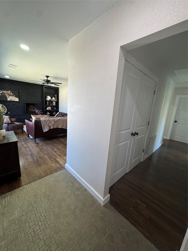 hall featuring recessed lighting, attic access, a textured ceiling, wood finished floors, and baseboards