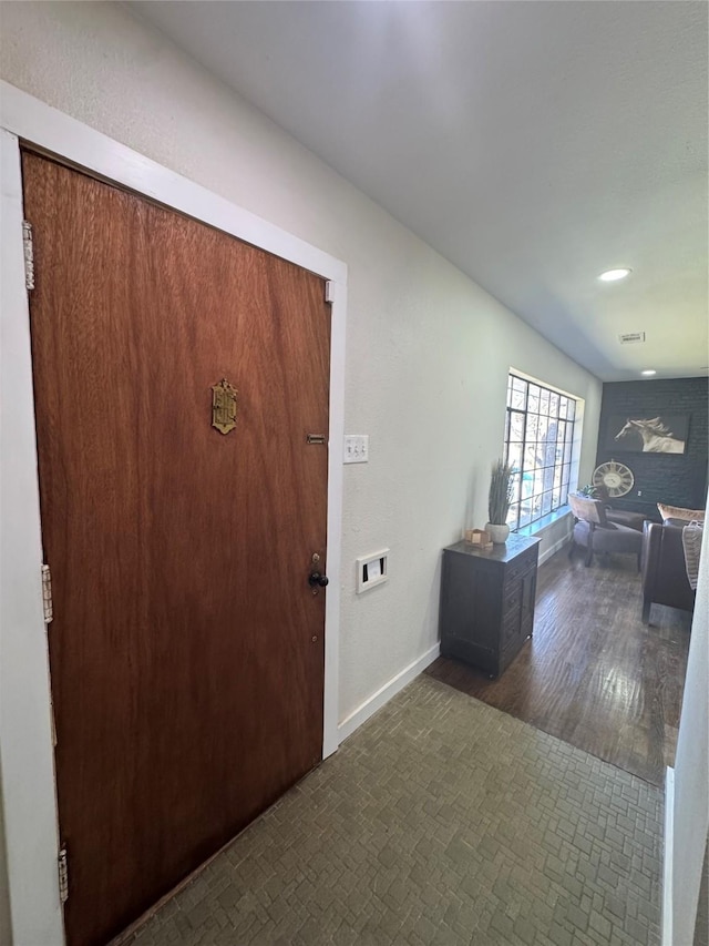 foyer with visible vents, baseboards, and wood finished floors