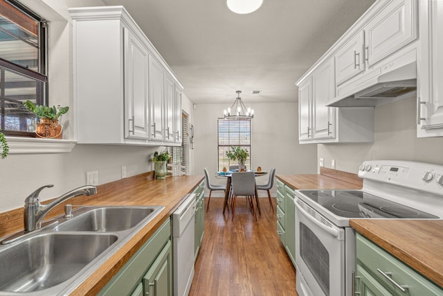 kitchen with a sink, under cabinet range hood, white appliances, wood counters, and green cabinetry