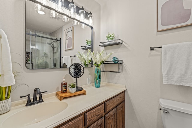 full bathroom with toilet, a stall shower, and vanity