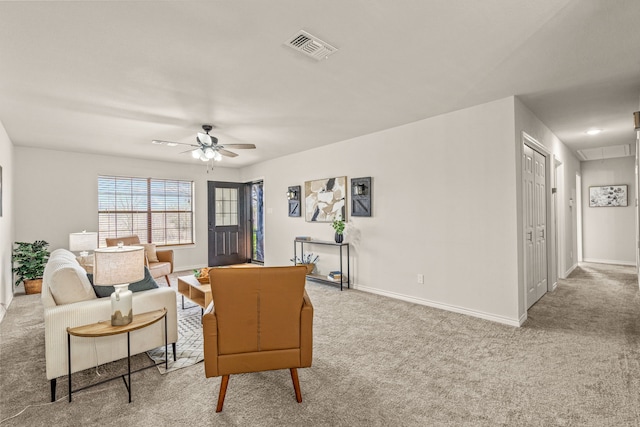 carpeted living room featuring visible vents, baseboards, attic access, and ceiling fan