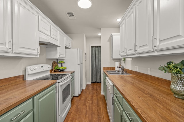 kitchen featuring green cabinetry, white appliances, butcher block countertops, and a sink