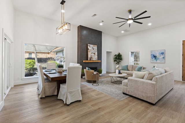 300 Covey Ln, Mckinney, TX 75071 - living area featuring a high ceiling, ceiling fan with notable chandelier, visible vents, and light wood finished floors