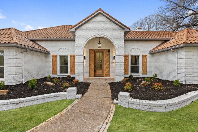 300 Covey Ln, Mckinney, TX 75071 - mediterranean / spanish home featuring a front yard, a tiled roof, brick siding, and a chimney