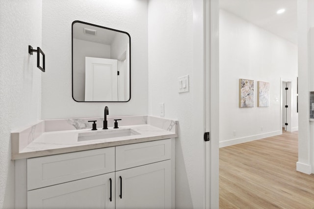 300 Covey Ln, Mckinney, TX 75071 - bathroom with vanity, visible vents, wood finished floors, and baseboards