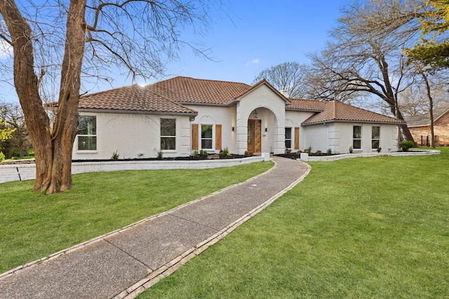 300 Covey Ln, Mckinney, TX 75071 - mediterranean / spanish home featuring a front yard, a tiled roof, and brick siding