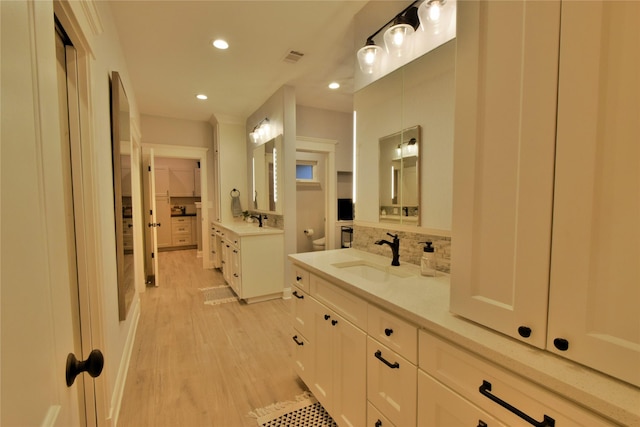 full bathroom with tasteful backsplash, a sink, toilet, and wood finished floors