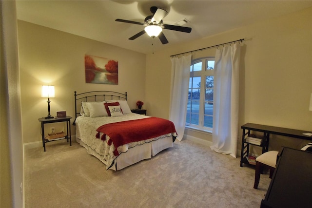 carpeted bedroom with visible vents, baseboards, and a ceiling fan