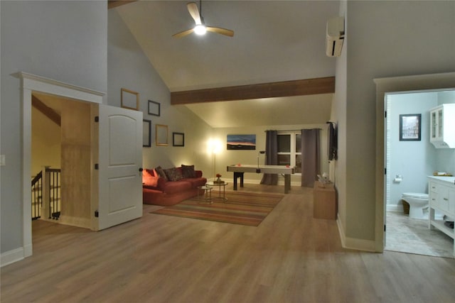 living area featuring a ceiling fan, high vaulted ceiling, wood finished floors, and a wall mounted air conditioner