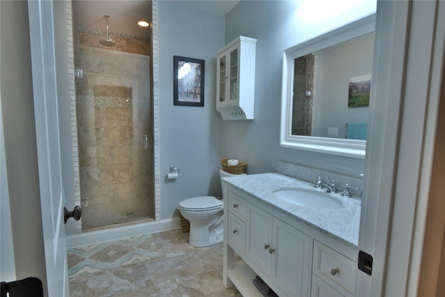 full bathroom with vanity, a shower stall, toilet, and baseboards