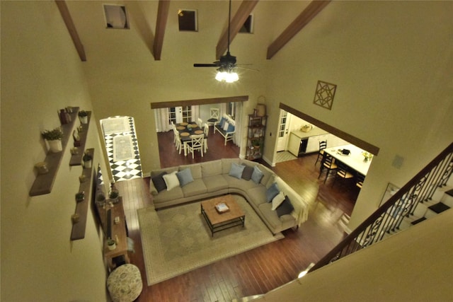 sunken living room featuring high vaulted ceiling, wood finished floors, a ceiling fan, stairs, and beam ceiling