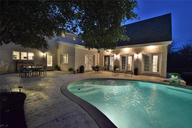 outdoor pool with french doors, a patio area, and outdoor dining space