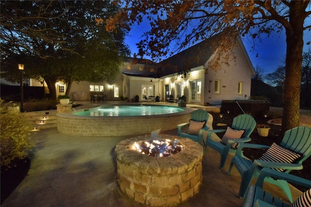 pool with a patio, an outdoor fire pit, and french doors