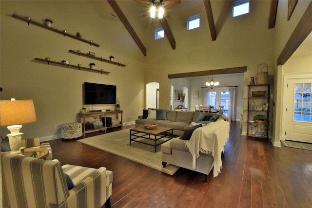 living area with ceiling fan with notable chandelier, a high ceiling, wood finished floors, and a wealth of natural light