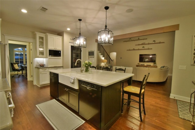 kitchen with dishwashing machine, a sink, visible vents, white cabinetry, and dishwasher