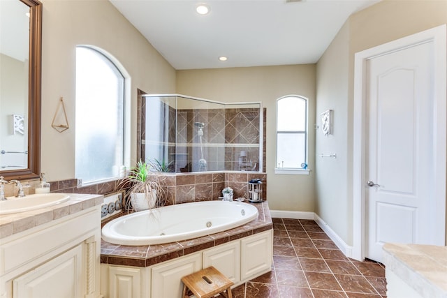 full bath with baseboards, tiled shower, a tub with jets, vanity, and recessed lighting