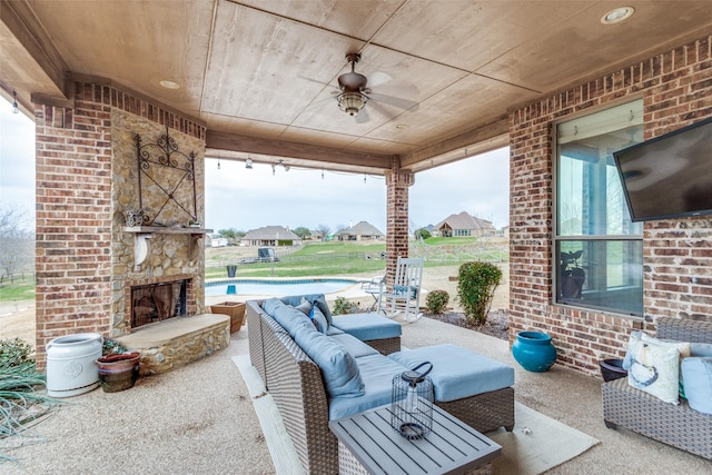 view of patio featuring a ceiling fan and an outdoor living space with a fireplace