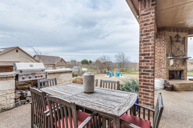 view of patio / terrace featuring an outdoor stone fireplace, outdoor dining area, and area for grilling