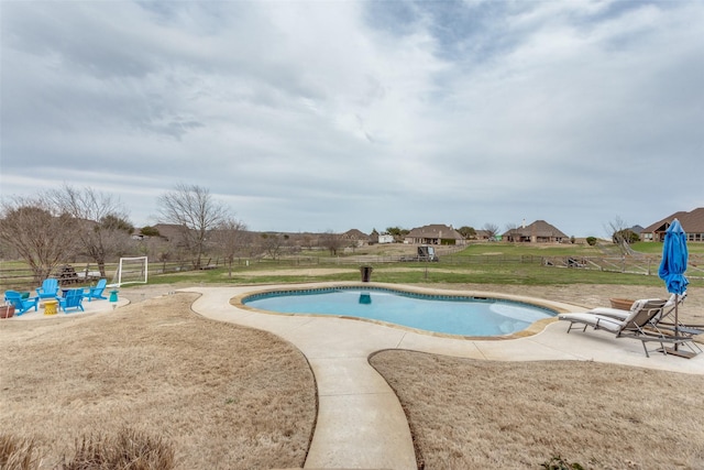 outdoor pool featuring a patio area, fence, and a yard