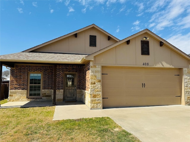 view of front of home with driveway, roof with shingles, a front yard, an attached garage, and brick siding