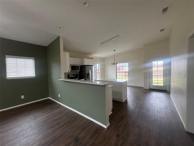 kitchen featuring dark wood-style floors, visible vents, a peninsula, stainless steel appliances, and white cabinetry