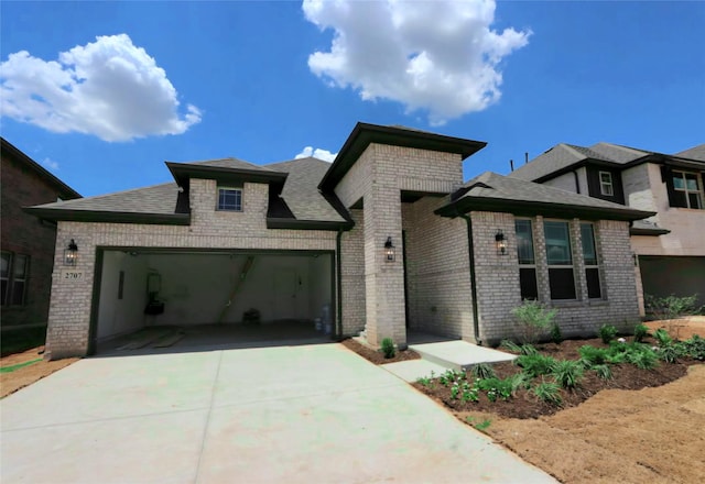 view of front of home featuring a garage, driveway, brick siding, and a shingled roof