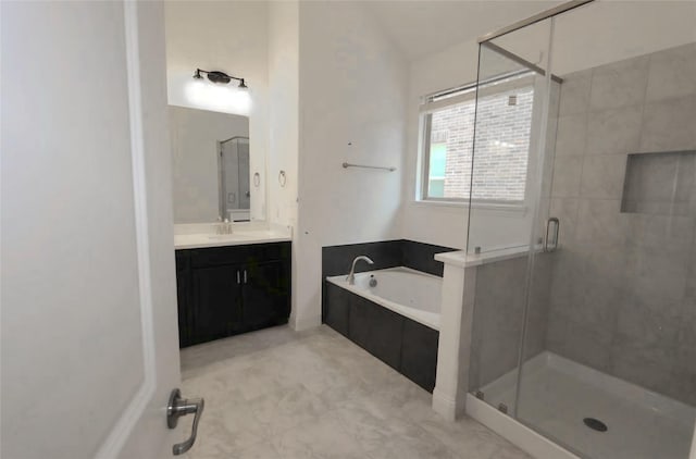 bathroom featuring a stall shower, a garden tub, and vanity