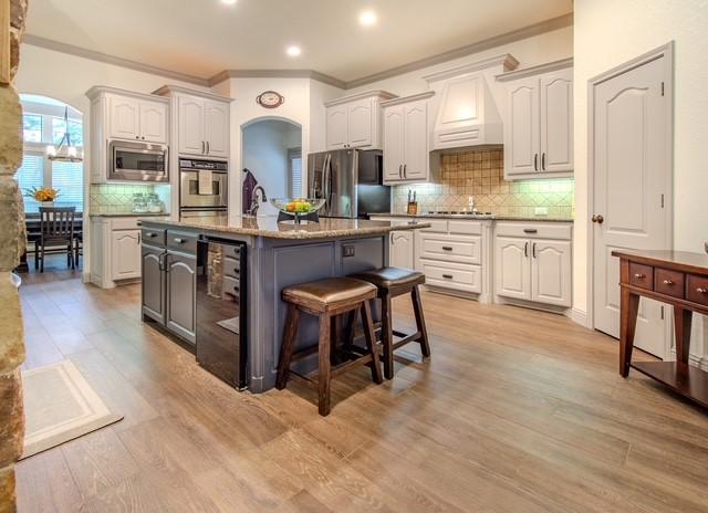 kitchen with arched walkways, custom exhaust hood, appliances with stainless steel finishes, beverage cooler, and a kitchen breakfast bar