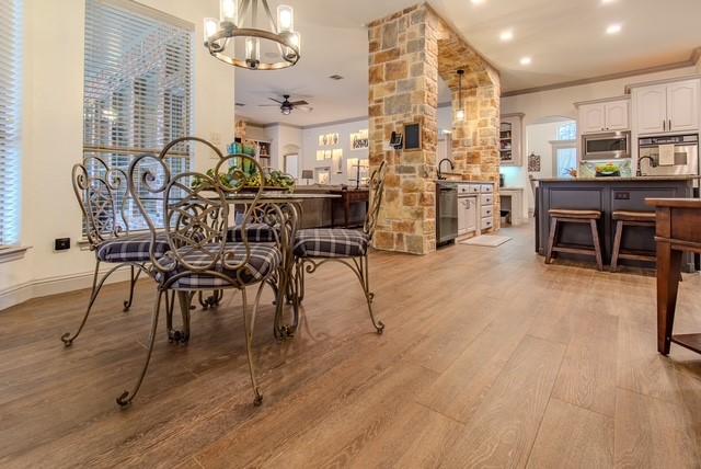 dining area with light wood-style flooring, ornamental molding, arched walkways, and ceiling fan with notable chandelier