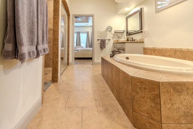 bathroom featuring connected bathroom, vanity, a bath, and tile patterned floors